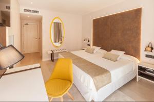 1 dormitorio con 1 cama grande y 1 silla amarilla en Benidorm Centre - Adults Only, en Benidorm