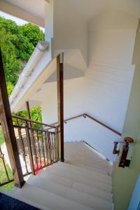 a staircase in a white house with a window at Cap-sud self catering in Au Cap