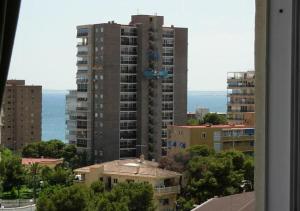 Blick auf ein hohes Gebäude aus dem Fenster in der Unterkunft Calablu in Alicante