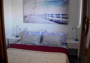 - une chambre dotée d'un lit avec une photo sur le mur dans l'établissement Calablu, à Alicante