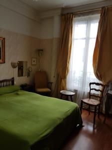 ニースにあるHotel Cronstadtのベッドルーム(緑のベッド1台、窓付)