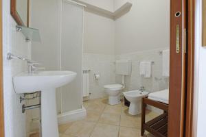 a white bathroom with a sink and a toilet at Cannatello home - Affittacamere in Villaggio Mosè
