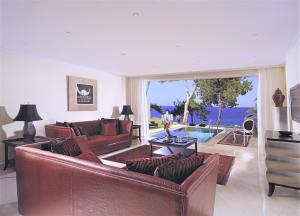 a living room with leather furniture and a view of the ocean at Out Of The Blue Resort & Spa in Agia Pelagia