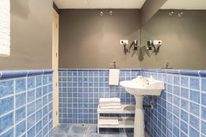 uma casa de banho com lavatório e azulejos azuis em GR0-Quiet apartment, Private backyard, Walk to Old Town em Málaga