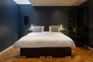 a bedroom with a large bed with blue walls at The Blossom House Amsterdam in Amsterdam