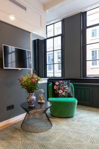 uma sala de estar com uma cadeira verde e uma mesa em The Blossom House Amsterdam em Amsterdã