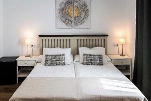 アランフェスにあるPosada de la Costurera de Aranjuezのベッドルーム(白い大型ベッド、ランプ2つ付)