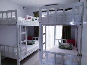 2 letti a castello bianchi in una camera con finestra di DKaYa Hostel a Khao Lak