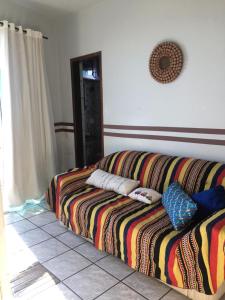 a couch in a living room with pillows on it at Kitnet em Ponta da Fruta in Ponta da Fruta