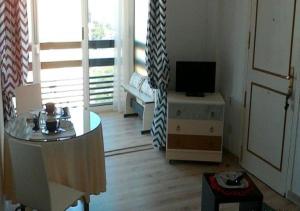 a living room with a table and a television at Cala Regina in San Juan de Alicante