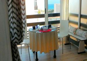 a table and chairs in a room with a window at Cala Regina in San Juan de Alicante