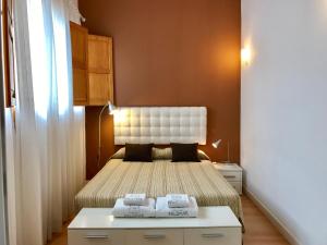 a small bedroom with a bed with a white headboard at Edificio Palomar - PalomarGroup in Valencia