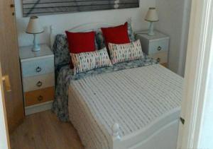 a bedroom with a bed with two night stands and two lamps at Cala Regina in San Juan de Alicante