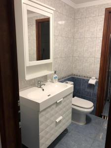 a bathroom with a sink and a toilet and a mirror at Islas Malvinas 39 Atico F in Vecindario