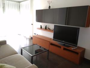sala de estar con TV de pantalla plana sobre una mesa en Apartamentos Deluxe Playa Norte, en Peñíscola