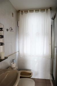 baño con aseo y lavabo y ventana en Alojamiento de Remedios, en Córdoba