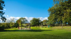a park with a swing set in the grass at Experience the Peace & Quiet in the North York Moors at Rawcliffe House Farm in Pickering
