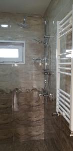 La salle de bains est pourvue d'une douche avec une porte en verre. dans l'établissement Sweet night, à Kazbegi