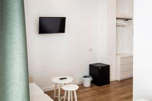 a room with two stools and a tv on a wall at Posada de la Costurera de Aranjuez in Aranjuez +47 photos