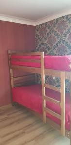 Cette chambre comprend 2 lits superposés avec des draps roses. dans l'établissement Sweet night, à Kazbegi