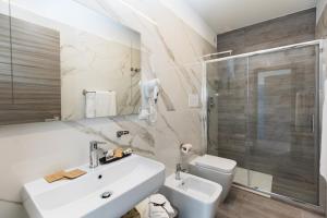 ein Bad mit einem Waschbecken, einem WC und einer Dusche in der Unterkunft L'Incanto di Paestum in Capaccio-Paestum