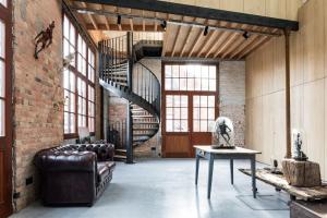a living room with a brick wall and a spiral staircase at b room in Bruges
