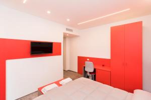 a bedroom with a white bed and a red wall at L'Incanto di Paestum in Capaccio-Paestum