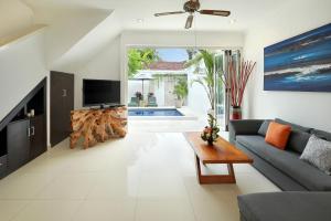 a living room with a couch and a tv at Villa Lamac in Legian