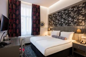 una camera d'albergo con un letto e una scrivania di Hotel Central Sarajevo - Gym, Pool & Spa a Sarajevo Altre 13 foto