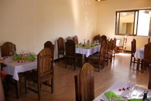 a dining room with white tables and wooden chairs at Tabor Hotel Lalibela in Lalibela +26 photos
