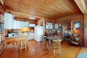 een keuken met witte apparatuur en een tafel en stoelen bij Island Lake House in Grand Isle