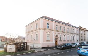 プラハにあるJane's Attic Apartmentの車が目の前に停まったピンクの建物