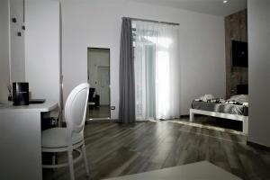 Habitación blanca con cama, mesa y sillas en Hermes rooms for tourists, en Nápoles