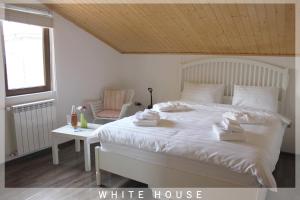 a white bedroom with a white bed and a chair at White House in Tbilisi City +62 photos