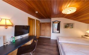 Habitación con cama y TV. en Hotel THE LARIX ski-in ski-out en Saas-Fee