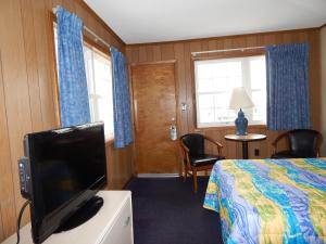 um quarto de hotel com uma cama e uma televisão de ecrã plano em Sun 'n Fun Motel em Ocean City