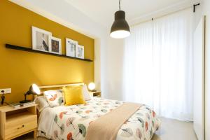 a bedroom with a bed and a lamp at Apartamentos Diaber San Leandro in Seville