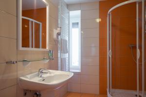 a bathroom with a sink and a shower at The Originals Boutique, Hôtel Terminus, Bourg-en-Bresse Gare (Qualys-Hotel) in Bourg-en-Bresse