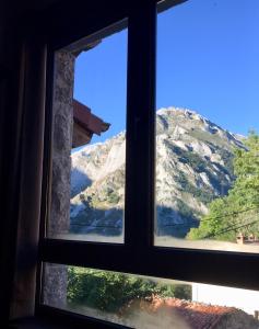 a window with a view of a mountain at La Cabaña de Catalina in Sotres