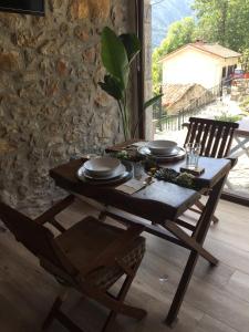 a wooden table with plates and glasses on it at La Cabaña de Catalina in Sotres