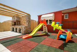 a childrens playground with a slide and play equipment at Villa Elpis 2 in Limenaria