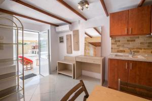 a kitchen with a sink and a table in a room at Villa Elpis 2 in Limenaria