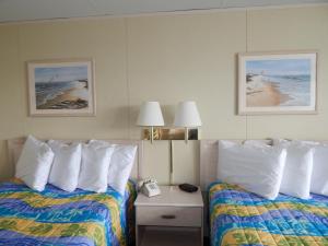 Una habitación de hotel con dos camas y un teléfono en una mesita de noche. en Thunderbird Beach Motel, en Ocean City 25 fotos más