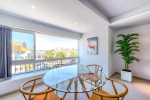 jadalnia ze szklanym stołem i krzesłami oraz oknem w obiekcie Luxury Penthouse Puerto Banús RDR403 w Marbelli