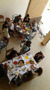 un grupo de personas sentadas alrededor de una mesa con comida en Ker Lep Jamm - Chez Moussa et Cinzia en Toubab Dialaw