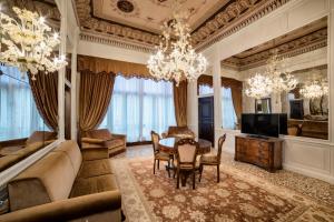 a living room with a table and chairs and a television at Hotel Nani Mocenigo Palace in Venice