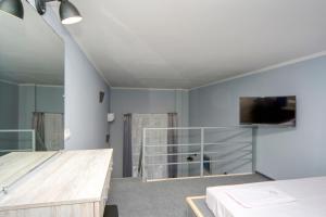 a bedroom with a bed and a tv on the wall at Grand Apartments in Kyiv