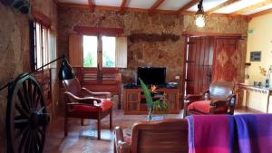 インヘニオにあるCasa Rural El Lirónのリビングルーム(テレビ、ソファ、椅子付)