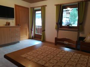 salon ze stołem, kanapą i oknami w obiekcie Ferienwohnung Angererhof w Reith im Alpbachtal