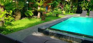 a swimming pool in the middle of a garden at Secret Garden Sky in Ubud